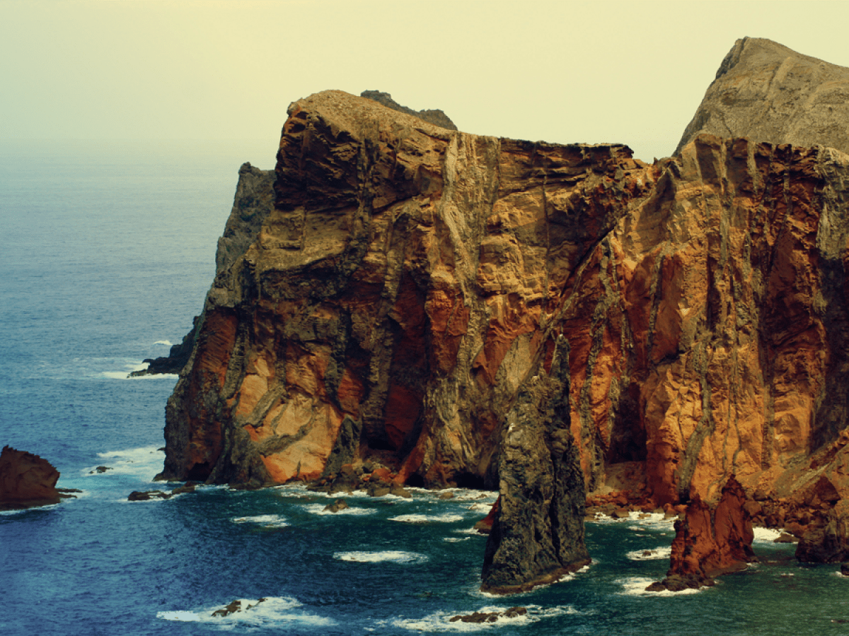 a rocky island in the middle of a body of water