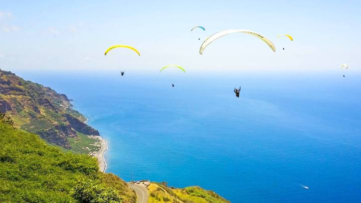a group of people flying kites in a body of water