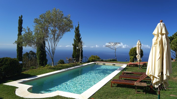 a couple of lawn chairs sitting on top of a grass covered field