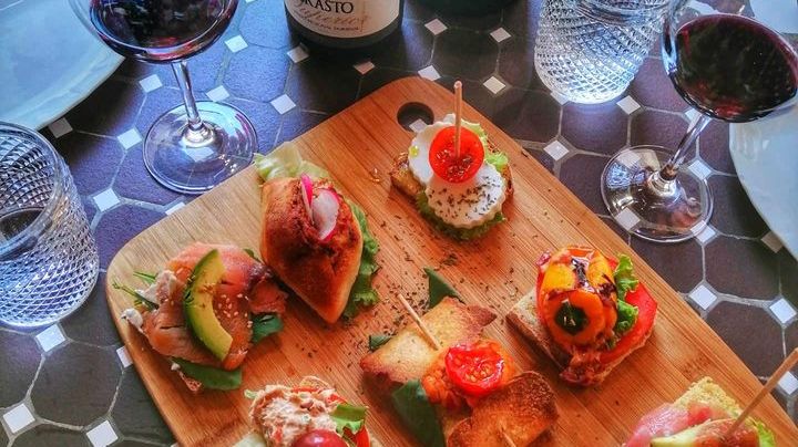 a pizza sitting on top of a wooden table topped with plates of food